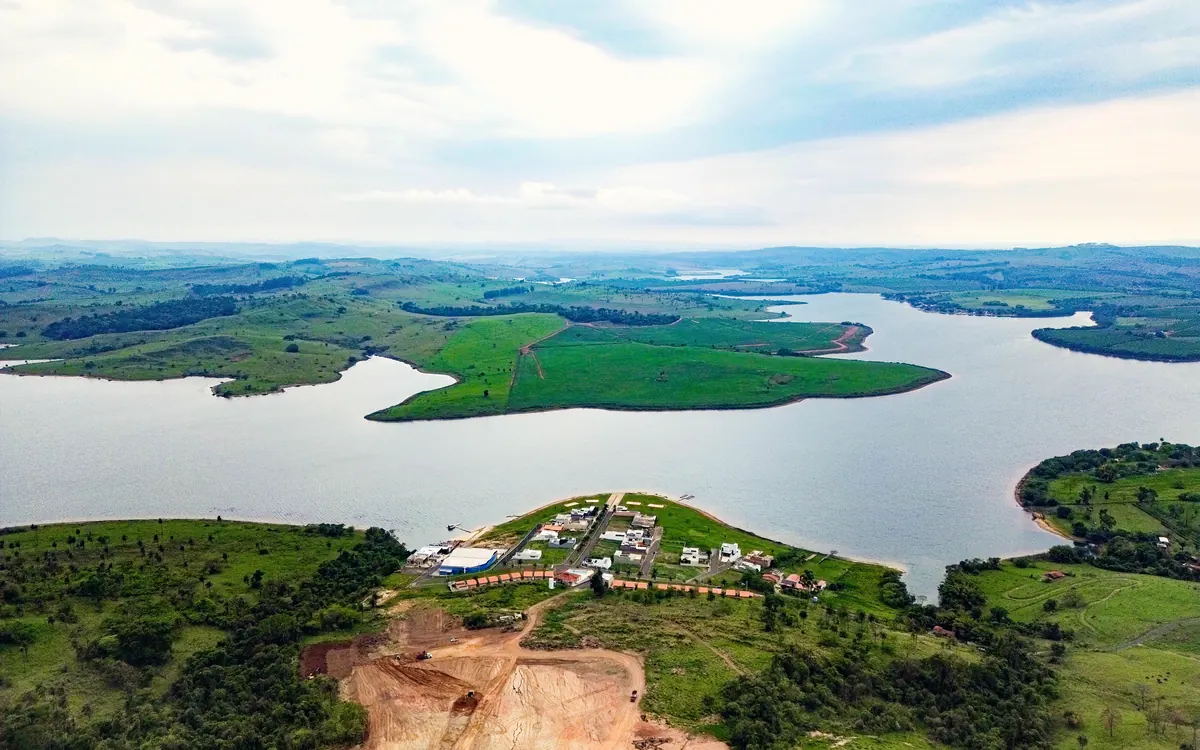 Vista aérea da fase I na ponta da península e da represa ao redor, com a terraplenagem da fase II ao fundo
